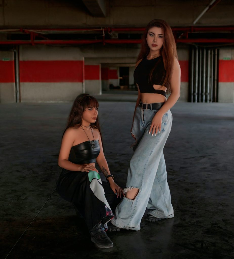 two women standing next to each other in a garage