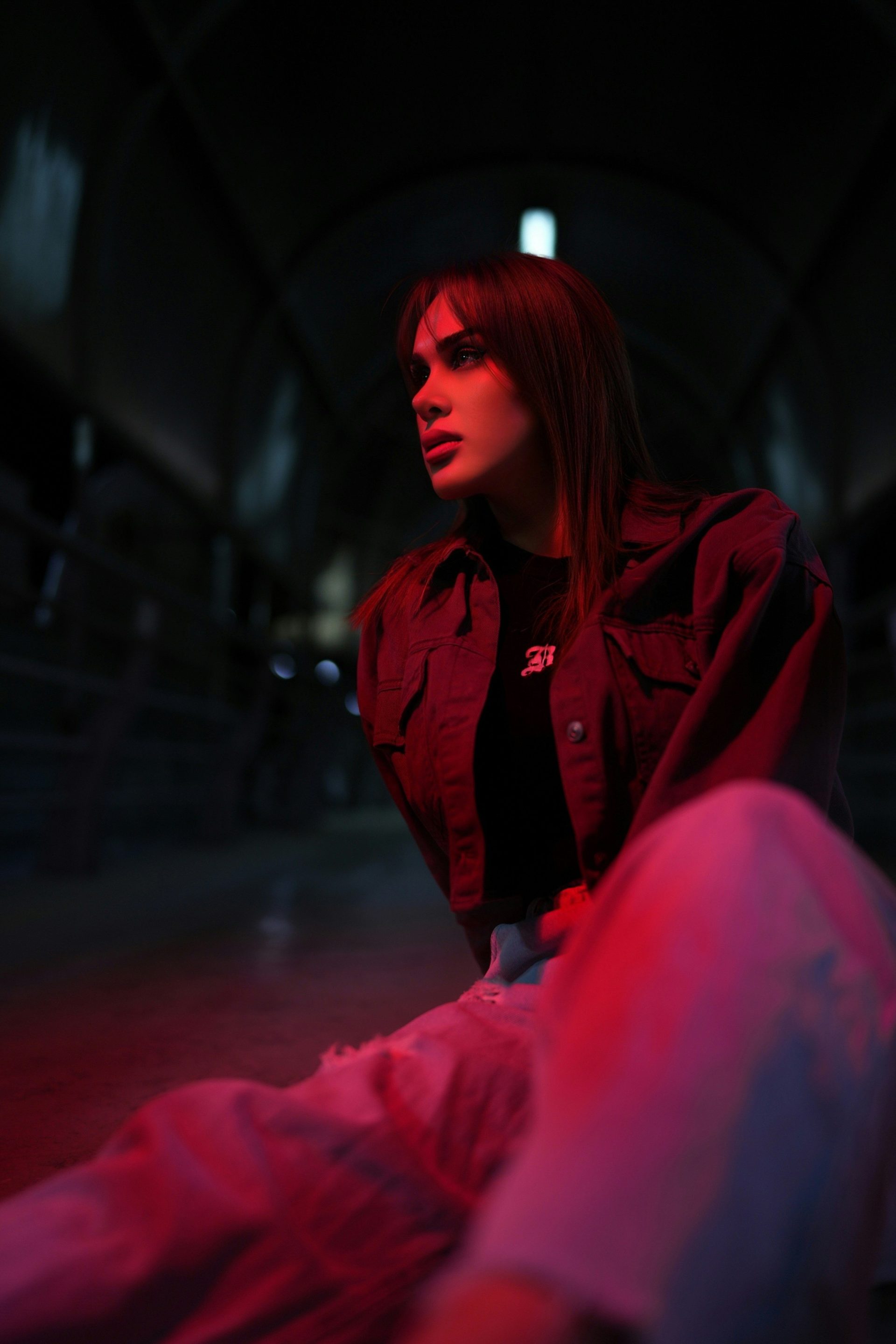 Young woman in denim jacket with red lighting