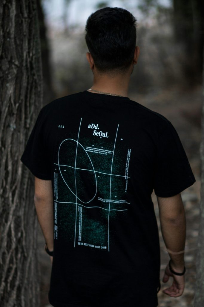 man in black crew neck t-shirt standing beside tree